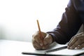 Close-up of man hand using writing pencil memo on notebook paper or letter, diary on table desk office. Royalty Free Stock Photo