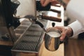 Close up man hand whipping milk for coffee by coffee machine in restaurant