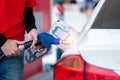 Close Up man handle pumping gasoline fuel nozzle in tank for car at gas station. power of transportation concept Royalty Free Stock Photo