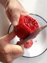 Top view of man hands cutting pomegranate with a knife Royalty Free Stock Photo