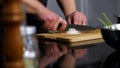 Close up of man hands cutting white onion on a wooden chopping board with a kitchen knife. Art. Preparing healthy food. Royalty Free Stock Photo