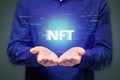 Close up of man hands holding creative glowing NFT hologram on dark background. Non-fungible token concept