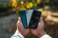 Close-up of man hands holding three different smartphones and deciding which one to choose. New phone, transferring data Royalty Free Stock Photo