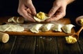 Close-up of a man hands making dumplings on the kitchen table for dinner. The concept of preparing dumplings in the kitchen of a Royalty Free Stock Photo