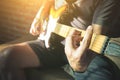 Close-up Man hands playing acoustic guitar with light flare Royalty Free Stock Photo