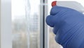 Close Up Man Hands with Protection Gloves Cleaning a Window Using Sprayed Liquid Disinfecting Against Viruses Royalty Free Stock Photo