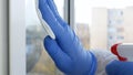 Close Up Man Hands with Protection Gloves Cleaning a Window Using Sprayed Liquid Disinfecting Against Viruses Royalty Free Stock Photo