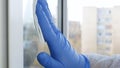 Close Up Man Hands with Protection Gloves Cleaning a Window Using Sprayed Liquid Disinfecting Against Viruses Contamination