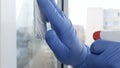 Close Up Man Hands with Protection Gloves Cleaning a Window Using Sprayed Liquid Disinfecting Against Viruses Contamination Royalty Free Stock Photo