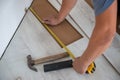Close up of man hands with roler installing laminate flooring in the new room. Worker covering flooe at home. renovation Royalty Free Stock Photo