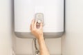 Close-up of man hands setting the temperature of water in Electric Boiler. Royalty Free Stock Photo