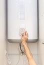 Close-up of man hands setting the temperature of water in Electric Boiler. Royalty Free Stock Photo