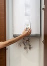 Close-up of man hands setting the temperature of water in Electric Boiler.