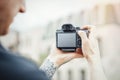 Close up of man hands holding camera and making photos of modern building. Royalty Free Stock Photo