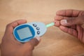 Close-up of man hands testing blood sugar with glucometer