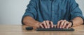 Close up of man hands typing on computer keyboard on wooden table at home office or workplace Royalty Free Stock Photo