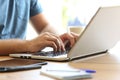 Man hands typing on a laptop keyboard on a desk