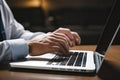 Close up of man hands typing on laptop keyboard while sitting at office desk, Businessman hand using smart phone and laptop Royalty Free Stock Photo