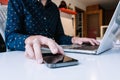 Close up of man hands using laptop checking smart phone Royalty Free Stock Photo