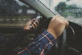 Close up of man hands using phone while driving a car, transportation and vehicle concept Royalty Free Stock Photo