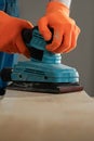 Close-up of man hands using sander machine on wood. construction concept. Royalty Free Stock Photo