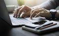 Close-up of man hands using and typing keyboard of laptop computer on office desk. Royalty Free Stock Photo