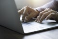 Close-up of man hands using and typing keyboard of laptop computer on office desk. Royalty Free Stock Photo