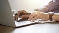 Close-up of man hands using and typing keyboard of laptop computer on office desk. Royalty Free Stock Photo