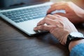 Close-up of man hands using and typing keyboard of laptop computer on office desk. Royalty Free Stock Photo