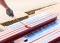 Close up man hold paint roller painting rustproof metal beam Royalty Free Stock Photo