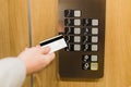 Close up of man holding cardkey on control panel elevator access concept