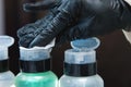 Close-up of a man holding a cotton pad and liquid cosmetics for makeup removal. beauty salon, a master in black special