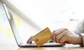 Close-up of a man holding a credit card and operating a laptop. Royalty Free Stock Photo