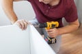 Handyman at work. Repairing kitchen shelves with cordless screwdriver Royalty Free Stock Photo