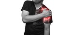 Man holding his injured shoulder that`s highlighted in red. Medical concept