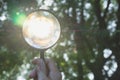 Close-up man holding magnifying glass for looking at the light