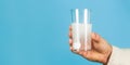 Close up of man holding a pill. Glass of water tablet. Glass with efervescent tablet in water with bubbles