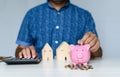 Close-up man holding a pink pig piggy bank and collecting coins in a piggy bank. Concept of men collects money for a home and car Royalty Free Stock Photo