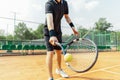 Close up of man holding racket at right hand and beating a tennis ball. Royalty Free Stock Photo