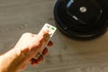 Close-up Of A Man Holding Remote Control Of Robotic Vacuum Cleaner To Start Cleaning. Royalty Free Stock Photo