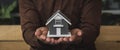 Close-up of a man holding a small house. Royalty Free Stock Photo