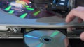 Close-up of Man Inserting Disc to DVD Player