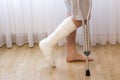 Close-up of man leg in plaster cast using crutches while walking. Royalty Free Stock Photo
