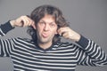Close up of man making silly monkey face isolated on grey background. Guy grimaces monkey. Funny male holding his ears