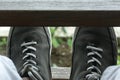 Close up of man mans feet with shoes between wooden fence. Relax time