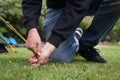 Close up of a man pegging down a tent on grass. Royalty Free Stock Photo