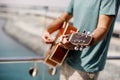 Close-up of a man playing a classical guitar while sitting on the beach in summer. Lifestyle, rest, relaxation Royalty Free Stock Photo