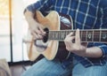 close up of a man playing guitar wih window light