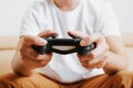 Close-up of man playing video game on console while sitting on couch at home Royalty Free Stock Photo