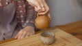 Close-up of man pouring Chinese tea. Art. Traditional Chinese tea with small teapot on wooden tray. Tea ceremony for one Royalty Free Stock Photo